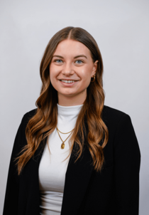 Porträtfoto eines weiblichen Teammitglieds mit langen blonden Haaren.